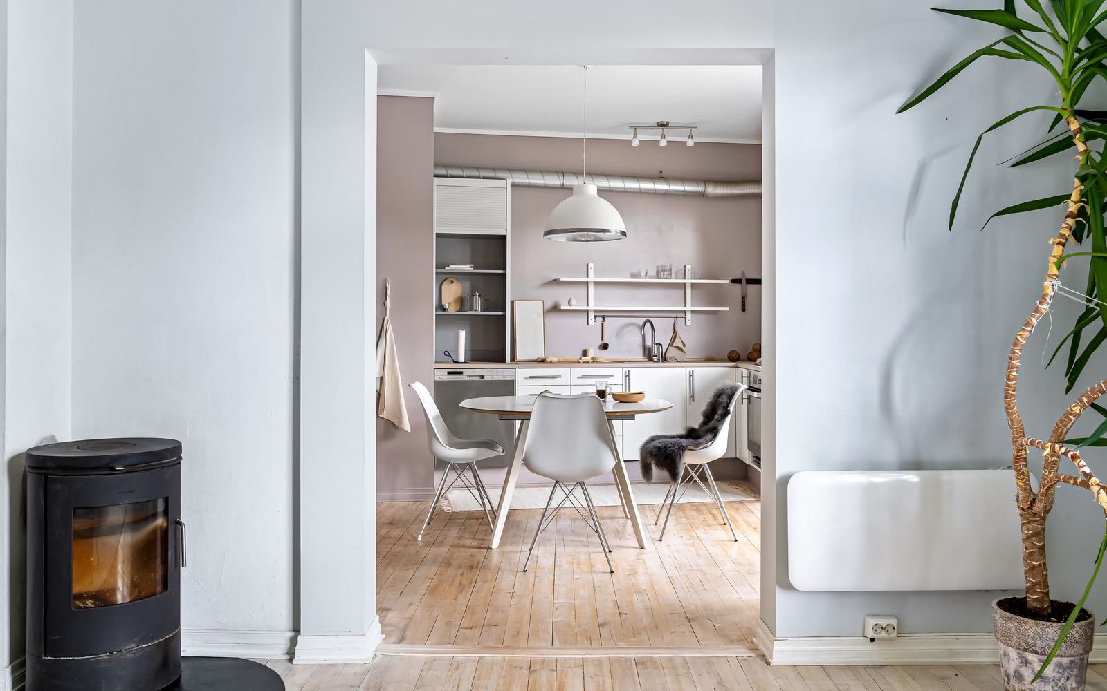 Kök med matplats sett genom valv, kamin i förgrunden