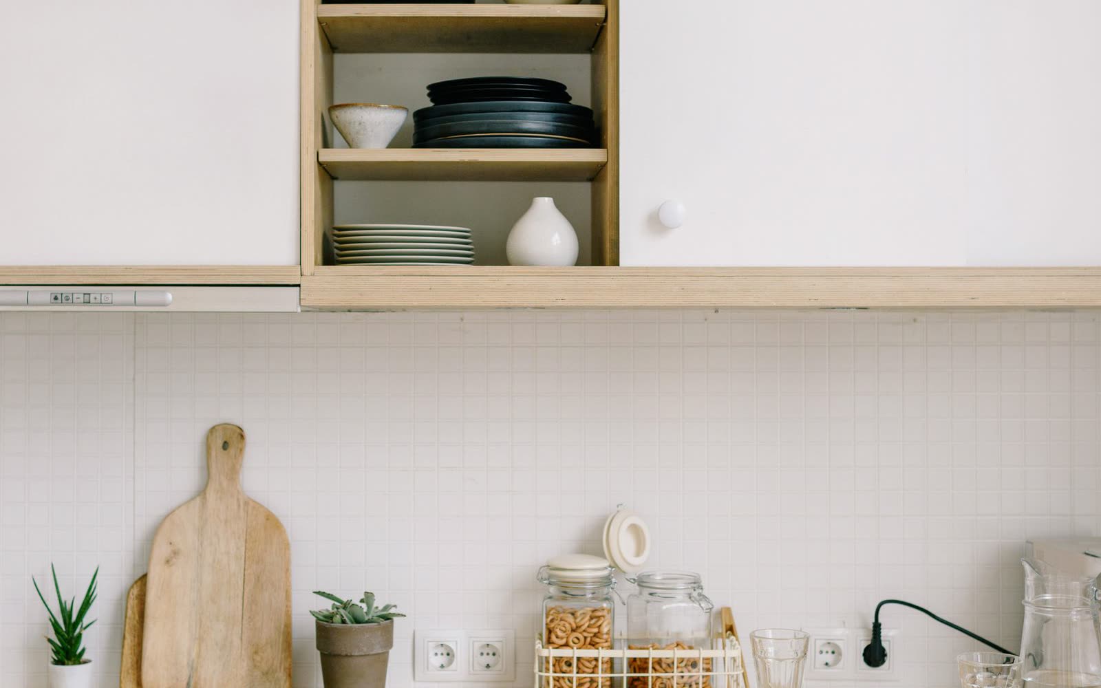 Plywoodkök med vita luckor och skjutdörrar