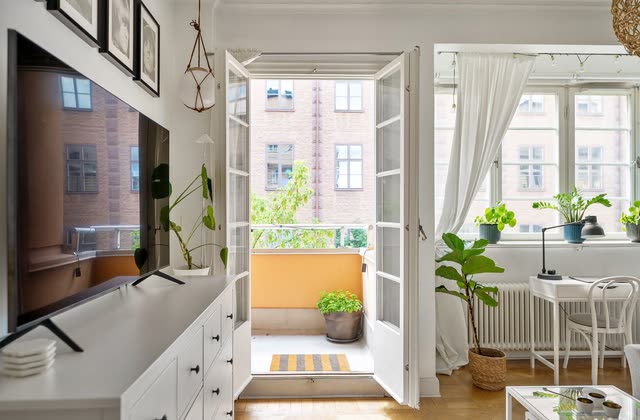 Ljus lägenhet med blå soffa, matbord och wishbone-stolar
