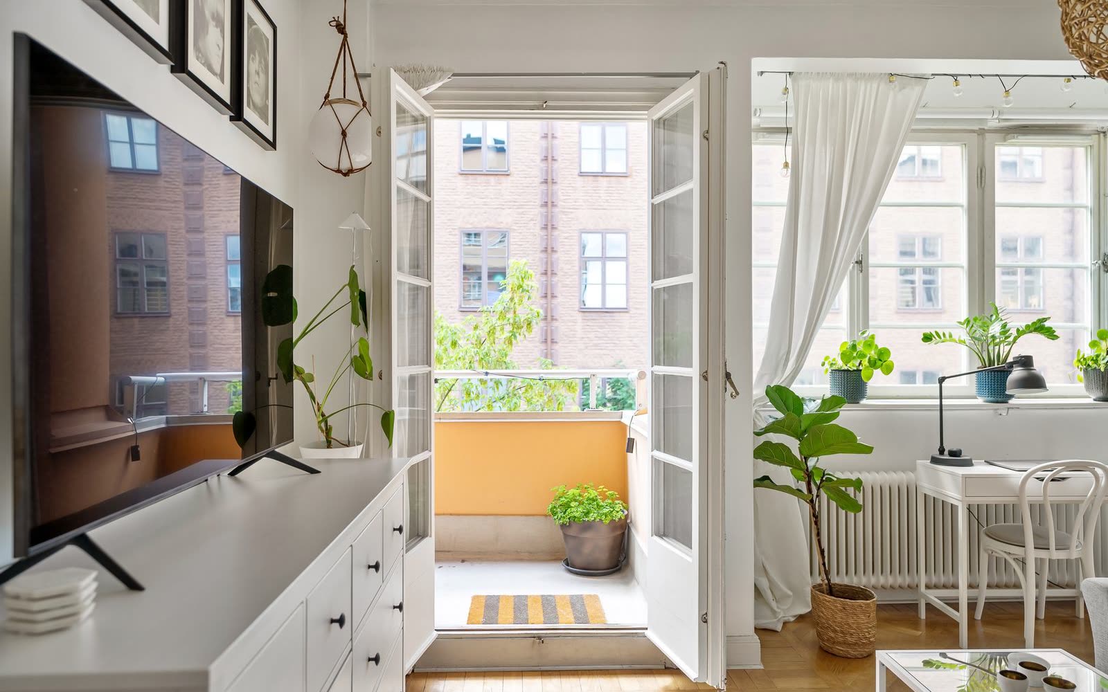 Ljus lägenhet med blå soffa, matbord och wishbone-stolar