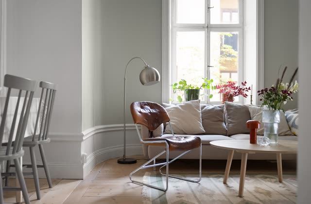 Soffgrupp i burspråk med läderfåtölj och trasmatta