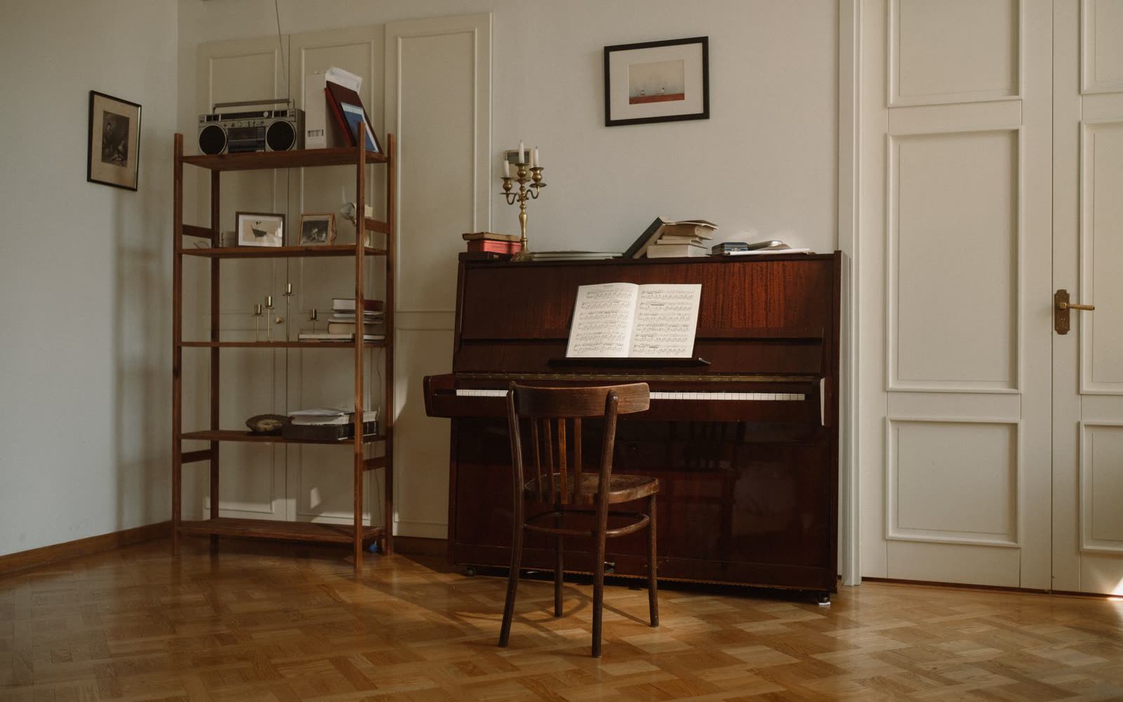 Rum med piano och stavparkett, vitmålade pardörrar