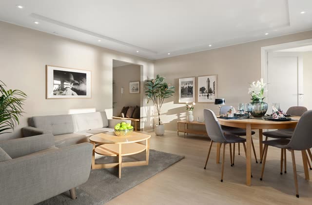 Beige vardagsrum med soffa, matplats och infälld belysning