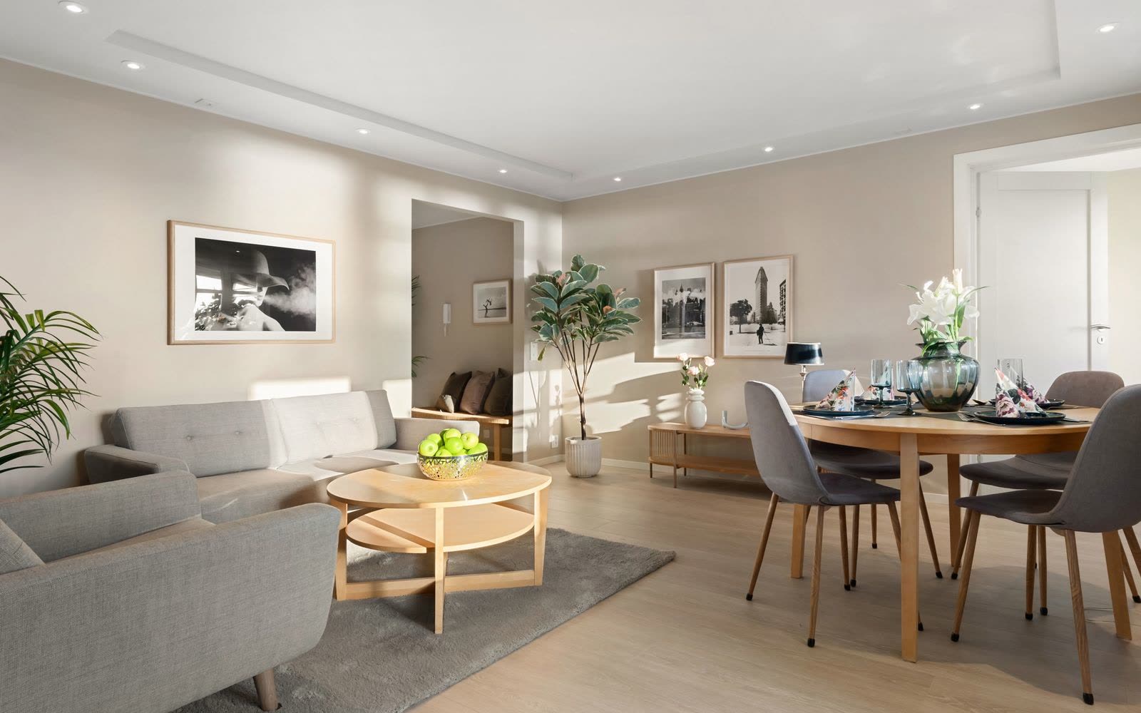 Beige vardagsrum med soffa, matplats och infälld belysning