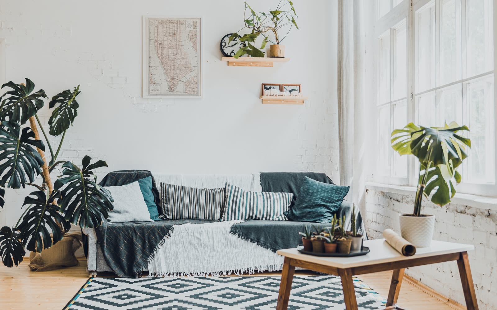 Vardagsrum med soffa, monstera och vitmålad tegelvägg