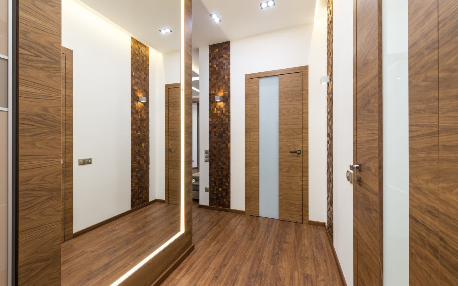 Hall med träpanel, spegel och ljusslinga